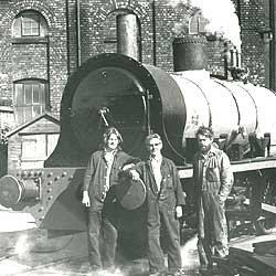 men standing steam engine